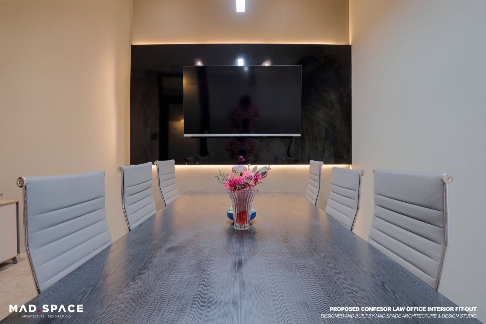Conference table facing a wall-mounted screen